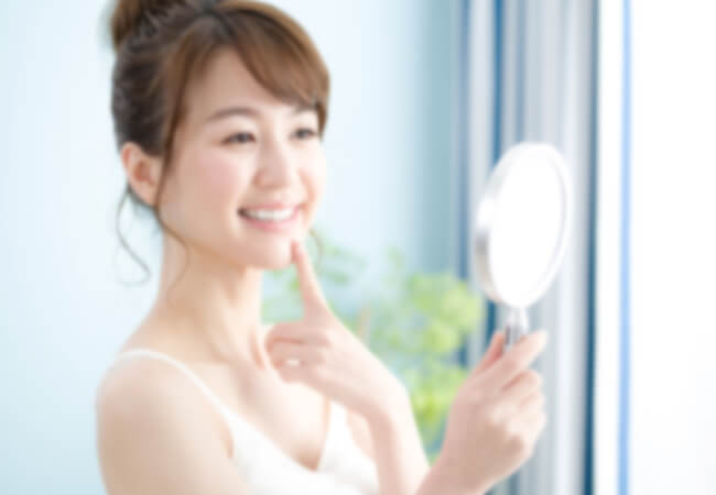 白い歯を確認する笑顔の女性